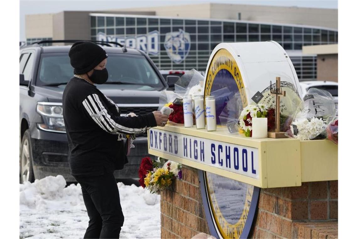 USA: Eltern des Schul-Schützen plädieren auf nicht schuldig Eine Frau hinterlässt am Schild der Oxford High School ein Plüschtier. Foto: Paul Sancya/AP/dpa
