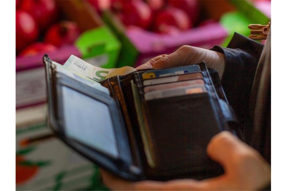 Eine Frau holt eine 5-Euro-Banknote aus ihrem Portemonnaie. Im Corona-Jahr 2020 haben weniger Menschen in Deutschland mit physischem Geld bezahlt. Foto: Fernando Gutierrez-Juarez/dpa-Zentralbild/dpa