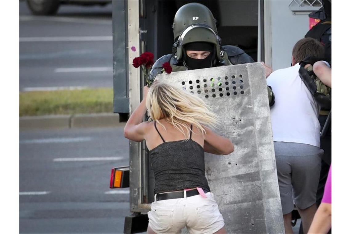 Protest und Gewalt in Belarus: Lukaschenko lehnt Dialog ab Eine Frau im Clinch mit einem Polizisten, nachdem viele Demonstranten festgenommen worden sind. Foto: -/AP/dpa