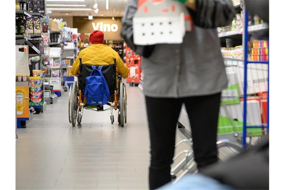 Eine Frau im Rollstuhl in einer Stuttgarter Edeka-Filiale. Foto: Sebastian Gollnow/dpa