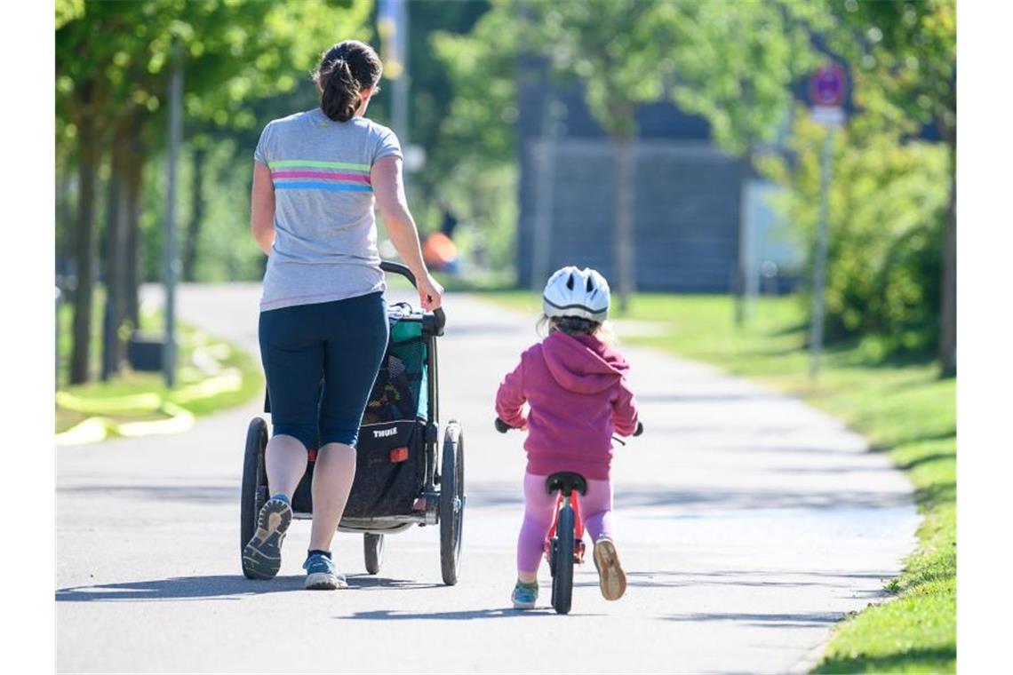 Eine Frau joggt mit ihrer Tochter, die eigentlich in der Kita wäre. Foto: Sebastian Gollnow/dpa