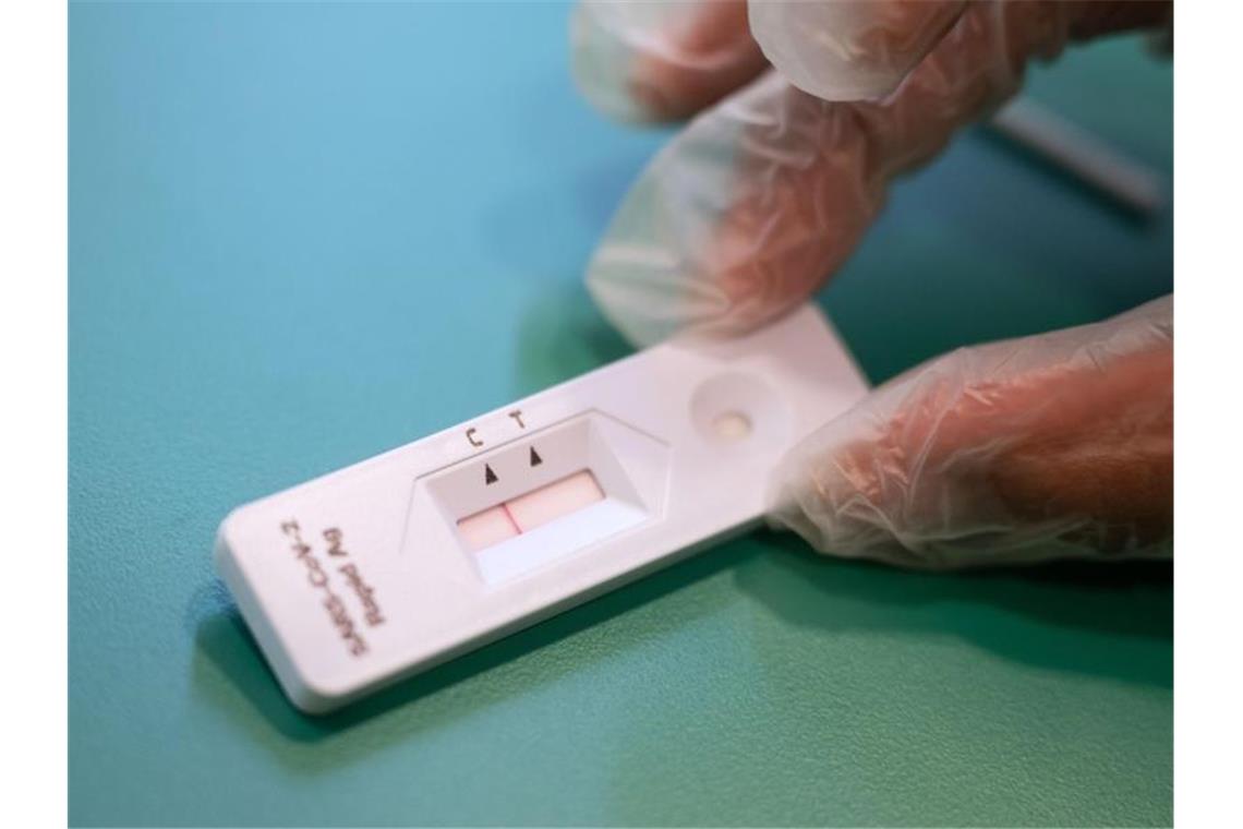 Tübingen weitet Vergabe kostenfreier Schnelltests aus Eine Frau kontrolliert die Anzeige eines Corona-Schnelltests. Foto: Marijan Murat/dpa/Archivbild