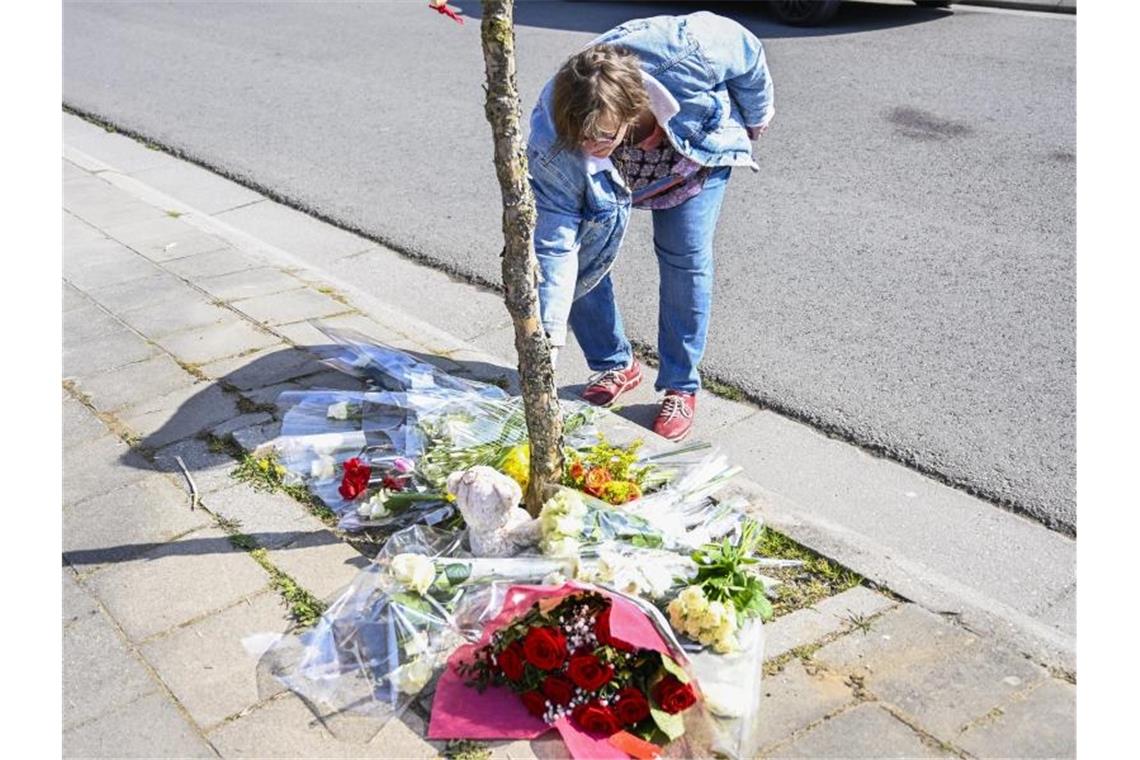 Todesfahrer in Belgien wegen fahrlässiger Tötung angeklagt Eine Frau legt Blumen an der Unfallstelle nieder. Foto: Laurie Dieffembacq/BELGA/dpa