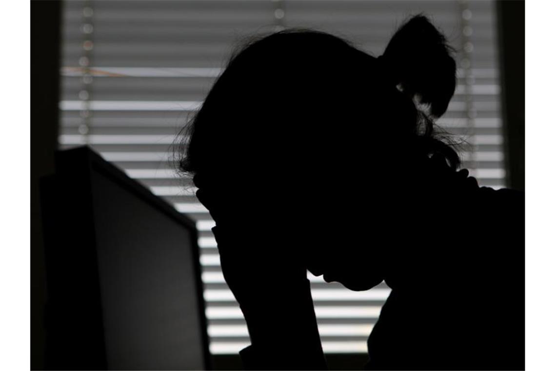 Psychische Krankheiten in Gesundheitsbranche am häufigsten Eine Frau legt ihren Kopf in die Hände. Foto: Marijan Murat/dpa/Archivbild