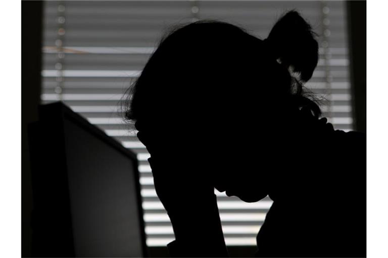 Eine Frau legt ihren Kopf in die Hände. Foto: Marijan Murat/dpa/Archivbild