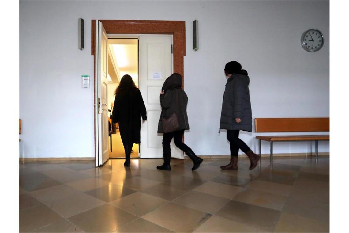 Eine Frau (M) betritt mit ihrem Rechtsbeistand einen Gerichtssaal im Landgericht. Foto: Karl-Josef Hildenbrand/dpa