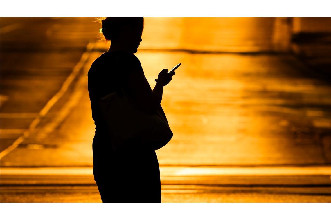 Eine Frau mit Handy - in der Netflix-Doku "Unbekannte Nummer: Der Highschool-Catfish" kommt der Psychoterror via Smartphone. (Symbolbild)
