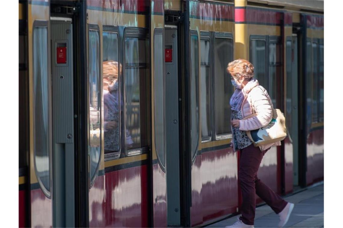 Eine Frau mit Mundschutz steigt in eine Berliner S-Bahn ein. Foto: Soeren Stache/dpa-Zentralbild/dpa
