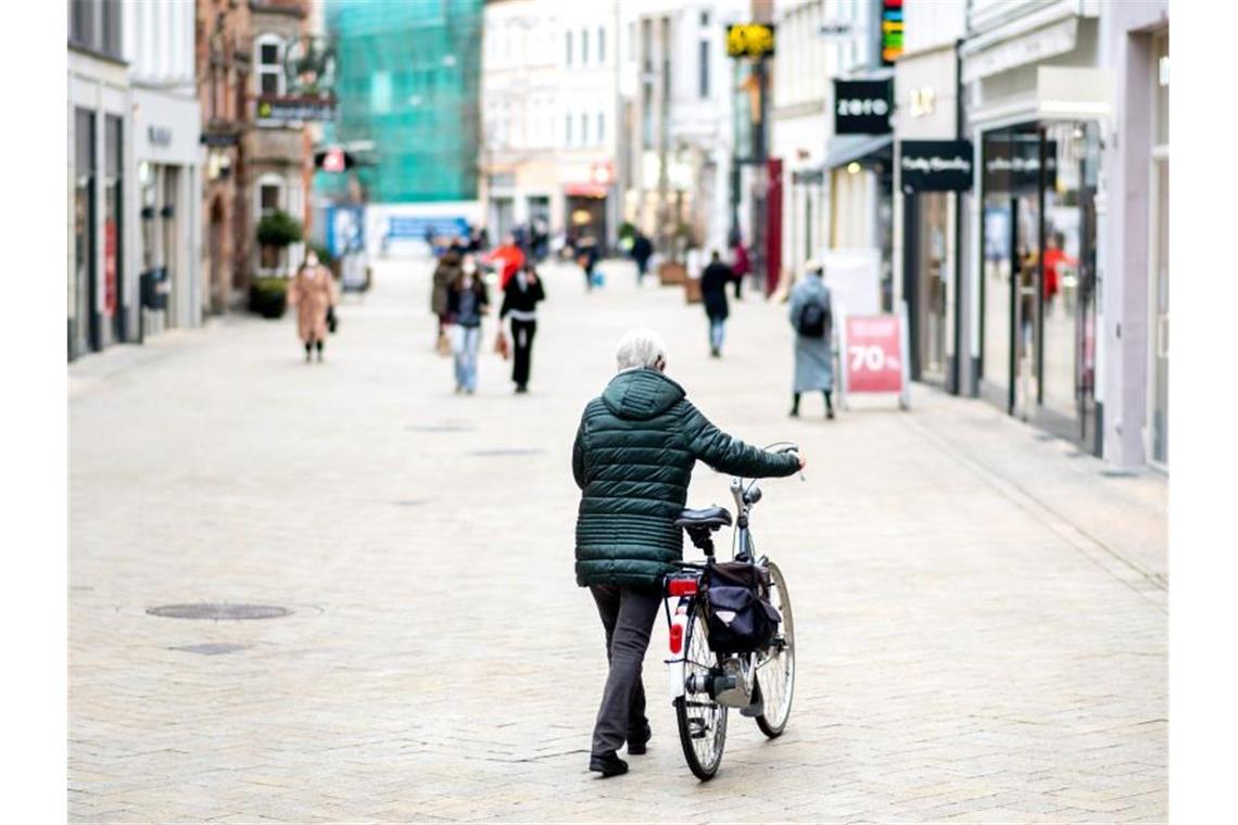 Ökonomen und Verbände kritisieren Corona-Beschlüsse Eine Frau schiebt ihr Fahrrad durch die wenig belebte Fußgängerzone in Oldenburg. Angesichts stark steigender Infektionszahlen wird der Lockdown in Deutschland verlängert. Foto: Hauke-Christian Dittrich/dpa