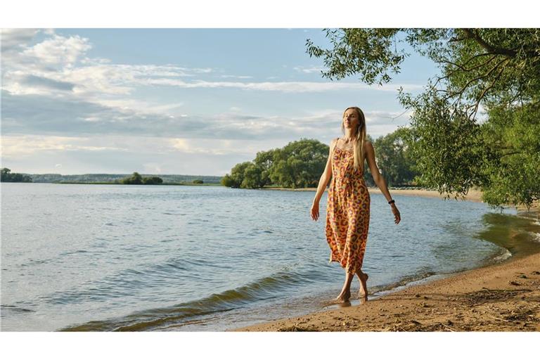 Eine Frau spaziert barfuß am Sandstrand: Der Bund für Umwelt und Naturschutz Deutschland gibt Ratschläge für einen abfallarmen Urlaub (Symbolfoto).
