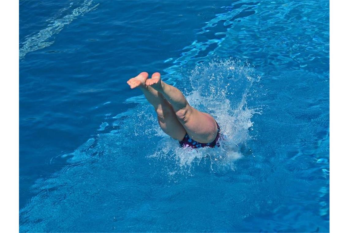 Eine Frau springt in einem Freibad ins Wasser. Foto: Martin Schutt/dpa-Zentralbild/dpa/Symbolbild