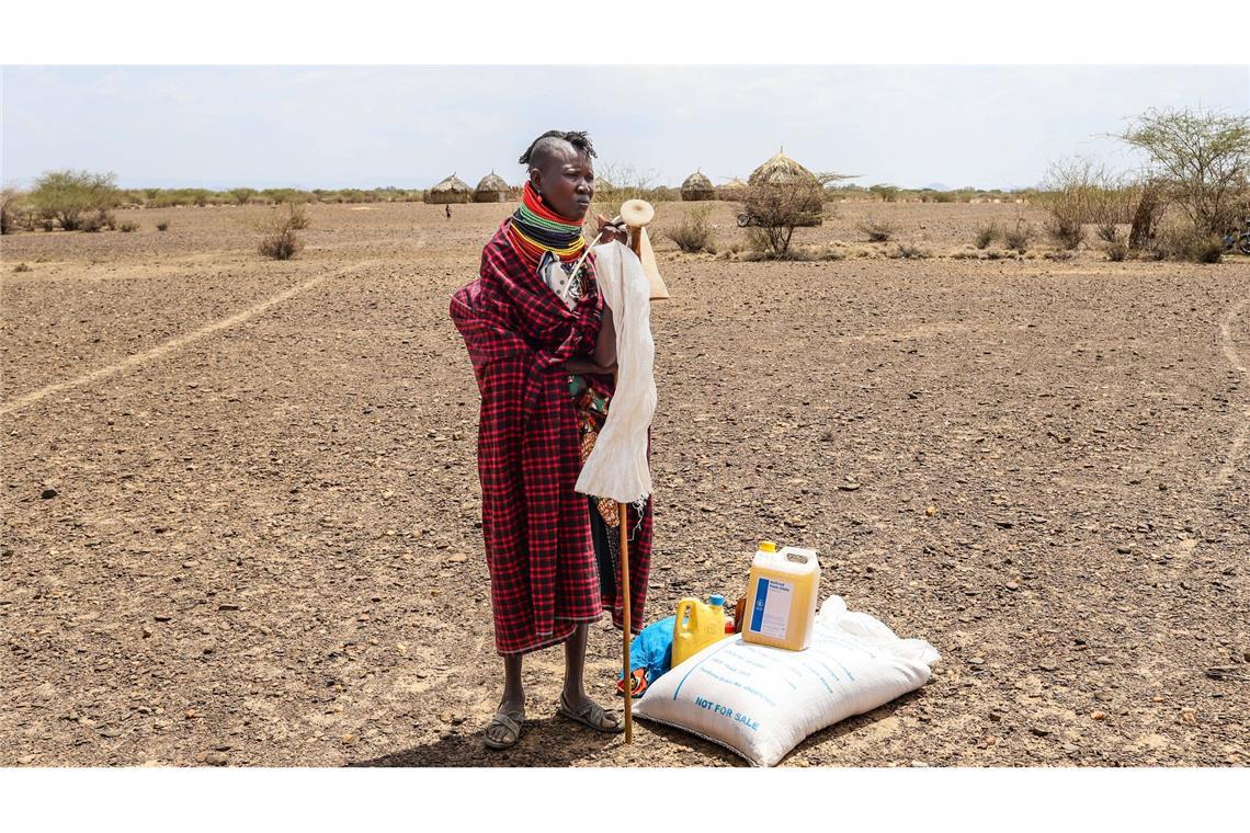 Eine Frau steht in Kenia neben einer Lebensmittelration des Welternährungsprogramms (WFP).