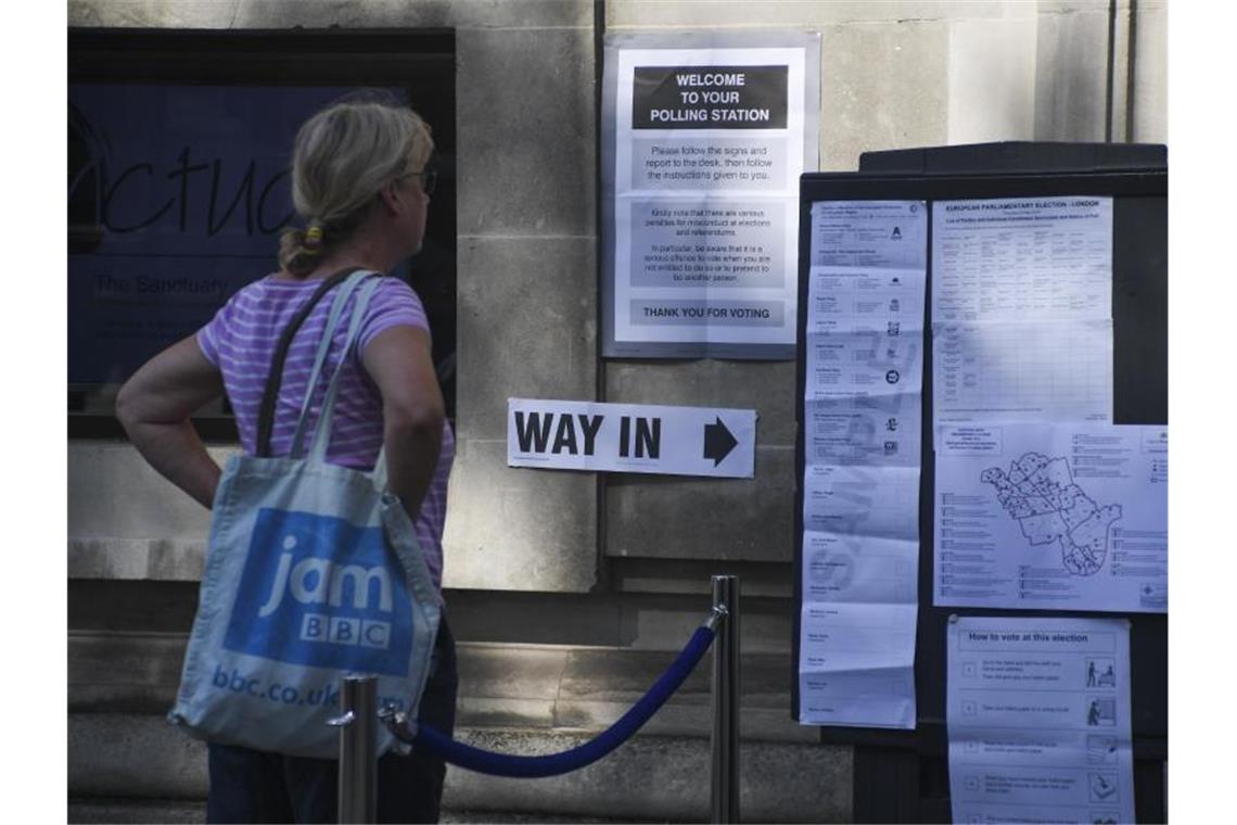 Eine Frau steht in London vor einem Wahllokal. Foto: Alberto Pezzali/XinHua