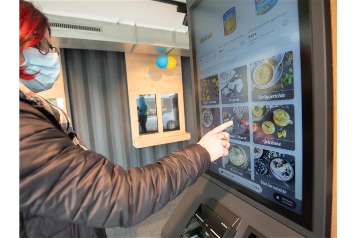 Mini-Supermarkt ohne Personal an Bahnhof eröffnet Eine Frau steht vor einem voll automatisierten Edeka-Supermarkt. Foto: Sebastian Gollnow/dpa/Archivbild