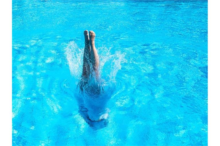 Eine Frau taucht im Inselbad ins Becken ein. Foto: Sebastian Gollnow/dpa/Symbolbild