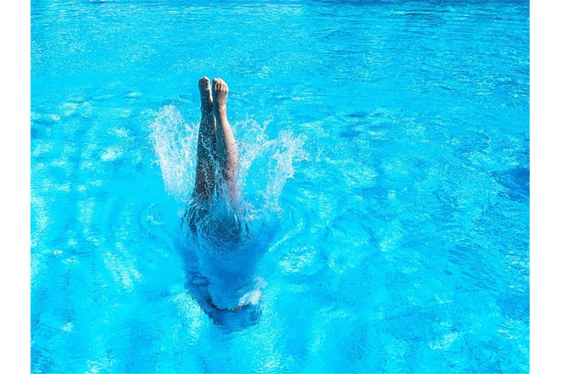 Eine Frau taucht in einem Stuttgarter Schwimmbad ins Becken ein. Foto: Sebastian Gollnow/dpa/Archivbild