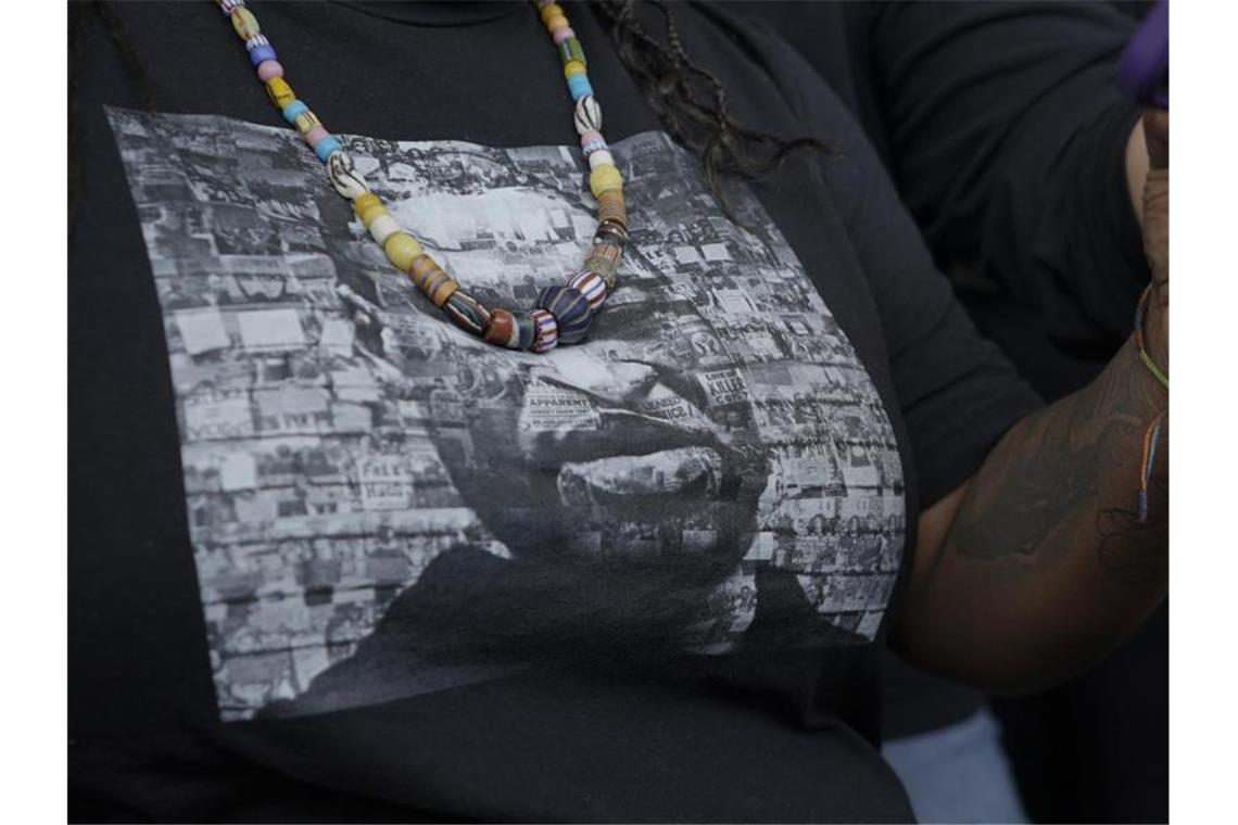 „Wendepunkt“ in USA? 22 Jahre Haft in Floyd-Prozess Eine Frau trägt ein T-Shirt mit einem Bild von George Floyd, während sie und andere Unterstützer die Anhörung zur Verurteilung des Ex-Polizisten Derek Chauvin verfolgen. Foto: Julio Cortez/AP/dpa