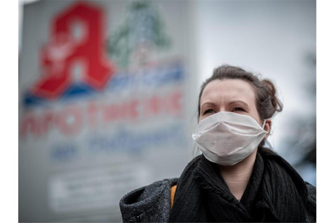 Heilbronn liegt bei Neuinfektionen landesweit an der Spitze Eine Frau trägt vor einer Apotheke eine Mund- und Nasenmaske. Foto: Fabian Strauch/dpa/Archivbild