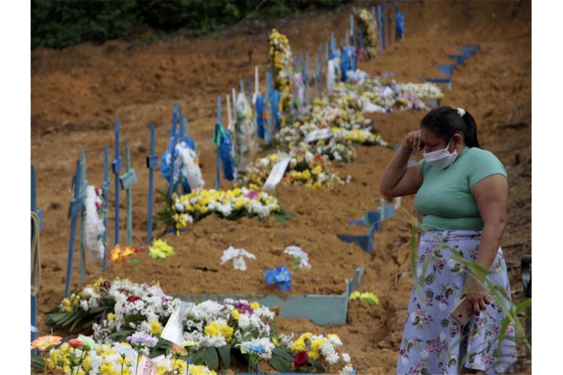 Eine Frau trauert an einem Grab auf einem Friedhof in Manaus. Foto: Altemar Alcantara/Semcom/Bürgermeisteramt Manaus/dpa
