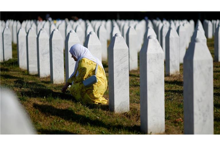 Eine Frau trauert neben dem Grab ihres Verwandten, der dem Völkermord von Srebrenica zum Opfer gefallen ist, im Memorial Center,