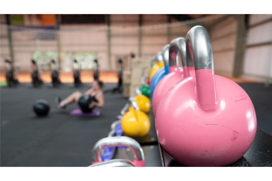 Eine Frau übt an einer Hantelbank.