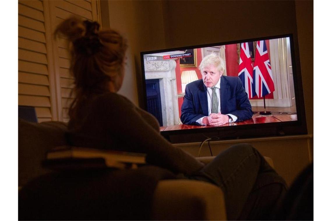 Johnson verkündet neuen nationalen Lockdown für England Eine Frau verfolgt im Fernsehen die Ansprache von Premierminister Boris Johnson an die Nation. Foto: Jacob King/PA Wire/dpa