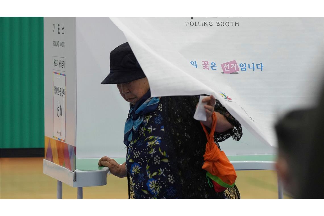 Eine Frau verlässt eine Wahlkabine, um ihre Stimme bei der Präsidentschaftswahl in Südkorea in einem Wahllokal abzugeben.