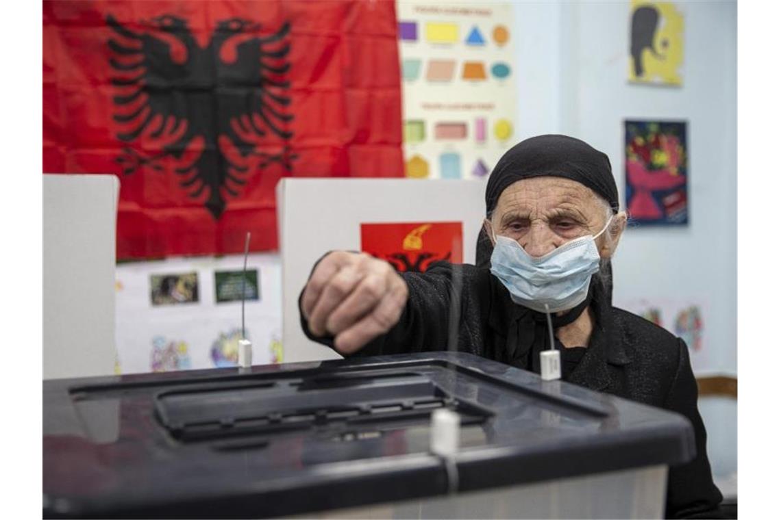 Hängepartie nach Parlamentswahl in Albanien Eine Frau wirft in Tirana ihren Stimmzettel in eine Wahlurne. Foto: Visar Kryeziu/AP/dpa
