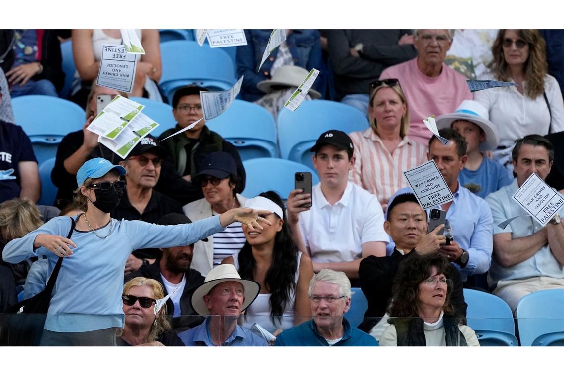 Eine Frau wirft während des Viertrundenmatches zwischen Alexander Zverev und Cameron Norrie bei den Australian Open in Melbourne Flugblätter mit der Aufschrift "Free Palestine" in die Luft.
