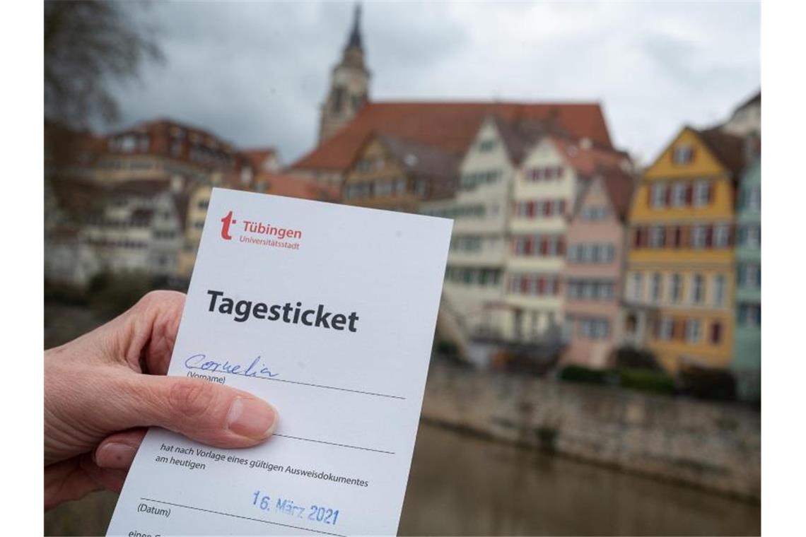 Tübinger Modellprojekt kann vorerst weitergehen Eine Frau zeigt am Neckar ihr „Tagesticket“, das aufgrund eines negativen Testergebnis bei einem Corona-Schnelltest ausgestellt wurde. Foto: Sebastian Gollnow/dpa/Archivbild