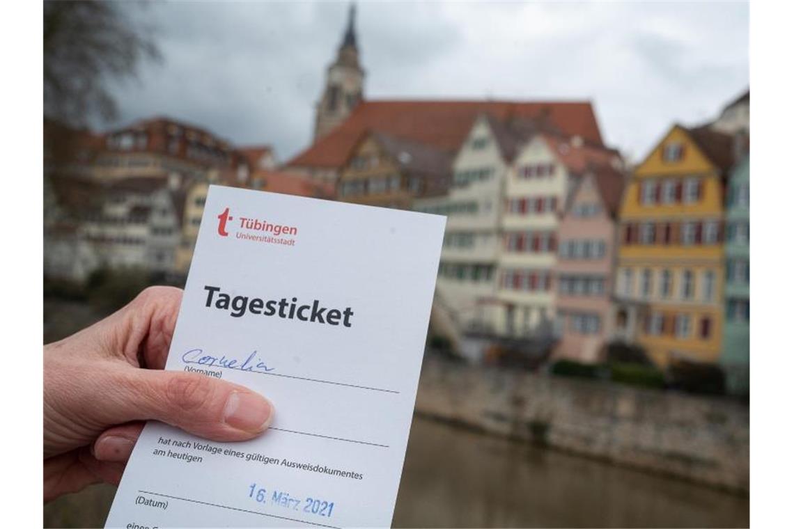 Eine Frau zeigt am Neckar ihr „Tagesticket“, das aufgrund eines negativen Testergebnis bei einem Corona-Schnelltest ausgestellt wurde. Foto: Sebastian Gollnow/dpa/Archivbild