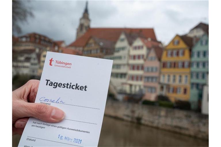 Eine Frau zeigt in Tübingen am Neckar ihr „Tagesticket“. Foto: Sebastian Gollnow/dpa/Archivbild