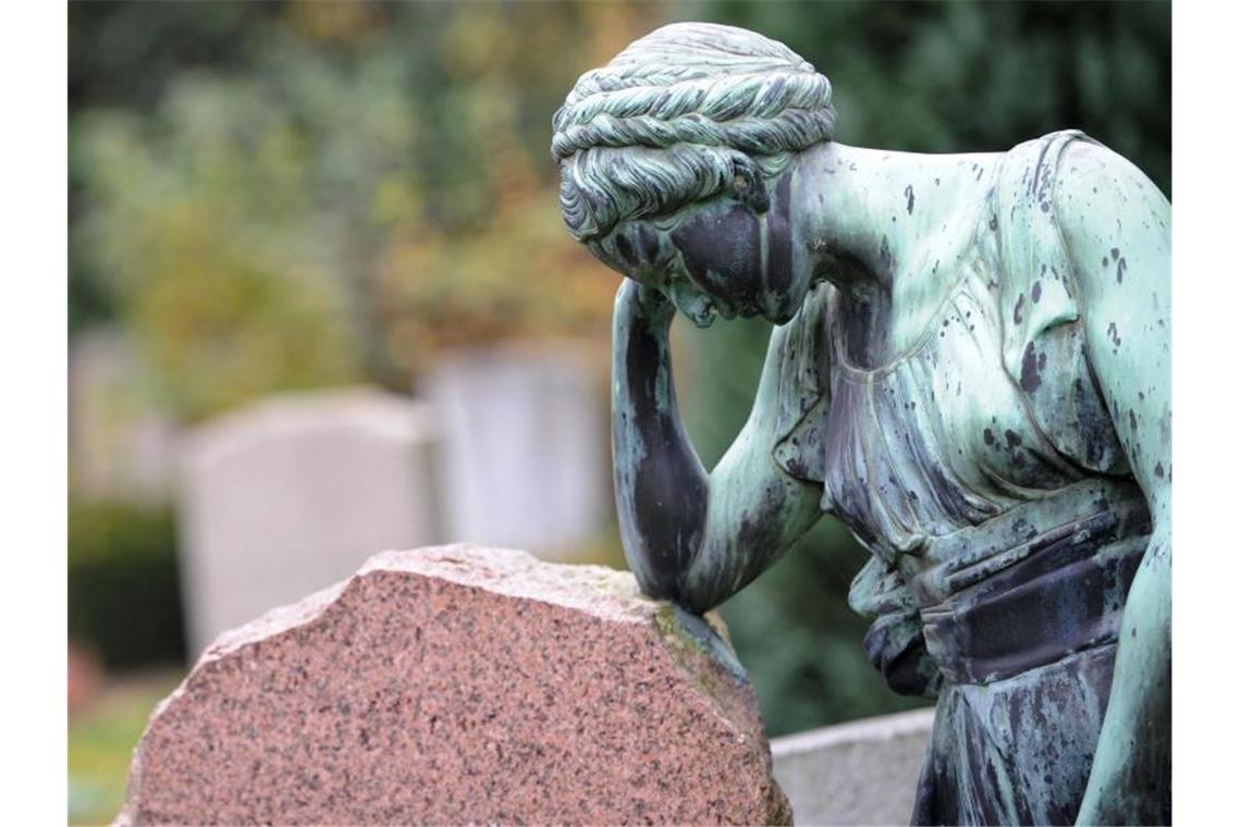 Sterblichkeit lag Ende April geringfügig über Durchschnitt Eine Frauenfigur lehnt an einem Grabstein. Foto: picture alliance / dpa
