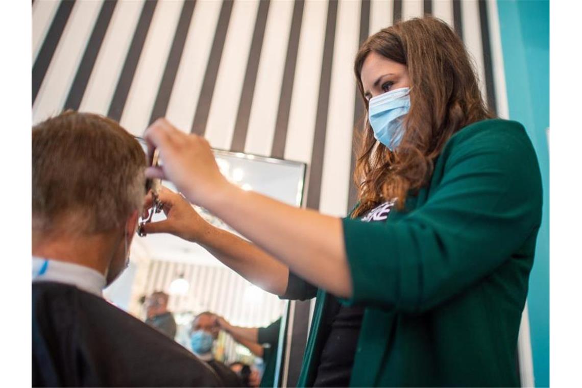 Eine Friseurin schneidet einem Kunden die Haarer. Foto: Klaus-Dietmar Gabbert/dpa-Zentralbild/ZB