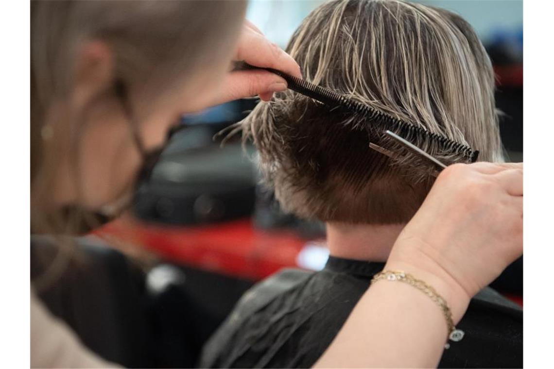 Mindestlohn steigt auf 9,60 Euro Eine Friseurin schneidet einer Kundin die Haare in einem Friseursalon. Foto: Magdalena Troendle/dpa