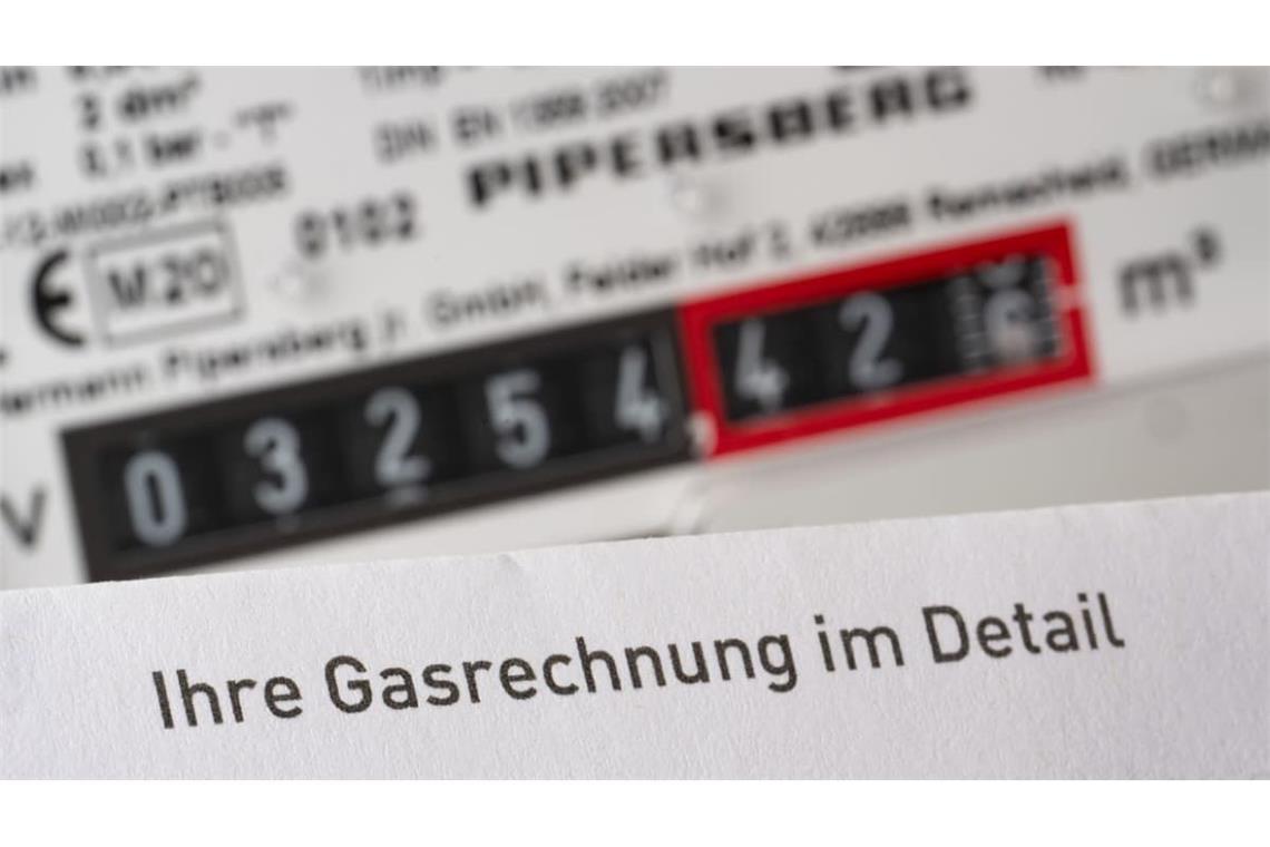 Eine Gasrechnung wird in einem privaten Haushalt vor einem Gaszähler gehalten (gestellte Szene). 