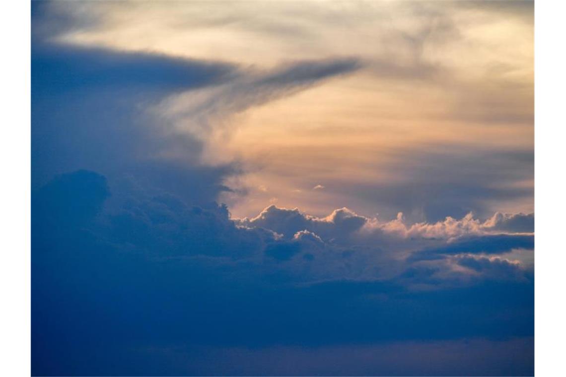 Eine Gewitterwolke, auch Gewitterzelle genannt, ist am Himmel im Sonnenuntergang zu sehen. Foto: Patrick Pleul/Archivbild