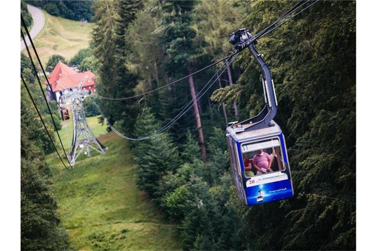 Eine Gondel hängt an ihrem Tragseil während im Hintergrund die Talstation zu sehen ist. Foto: Philipp von Ditfurth/dpa/Archivbild