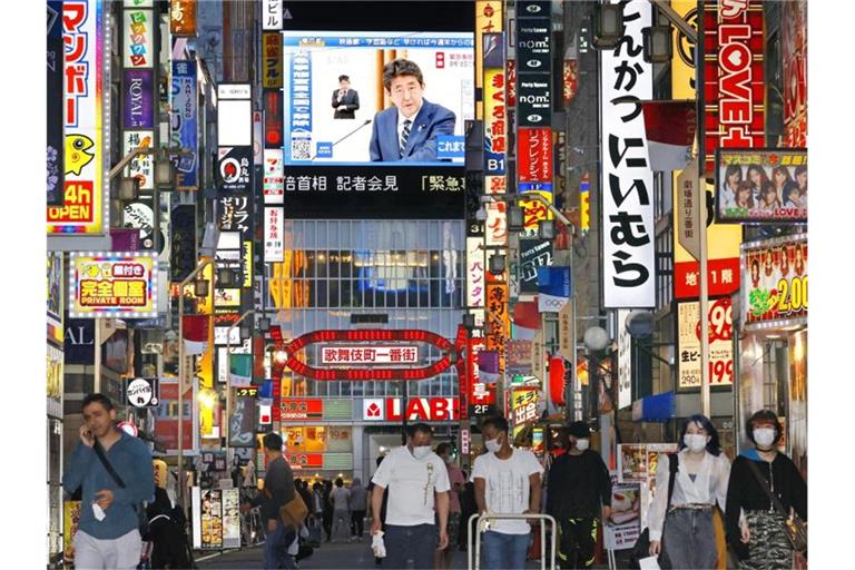 Eine große Leinwand in Tokio zeigt den japanischen Premierminister Shinzo Abe, der das Ende des Ausnahmezustands verkündet. Foto: -/kyodo/dpa