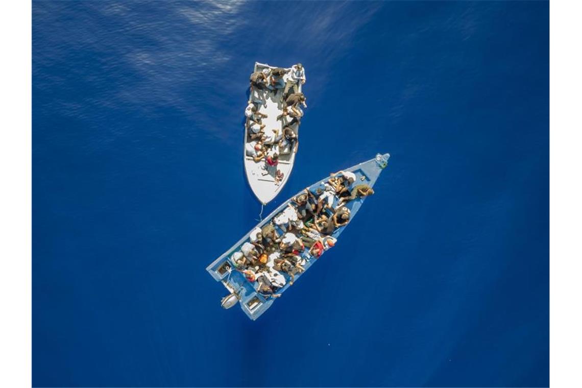 Dutzende Migranten bei Einsätzen im Mittelmeer gerettet Eine Gruppe mutmaßlicher Migranten aus Tunesien treibt auf zwei Booten im Mittelmeer vor der Insel Lampedusa. Foto: Santi Palacios/AP/dpa