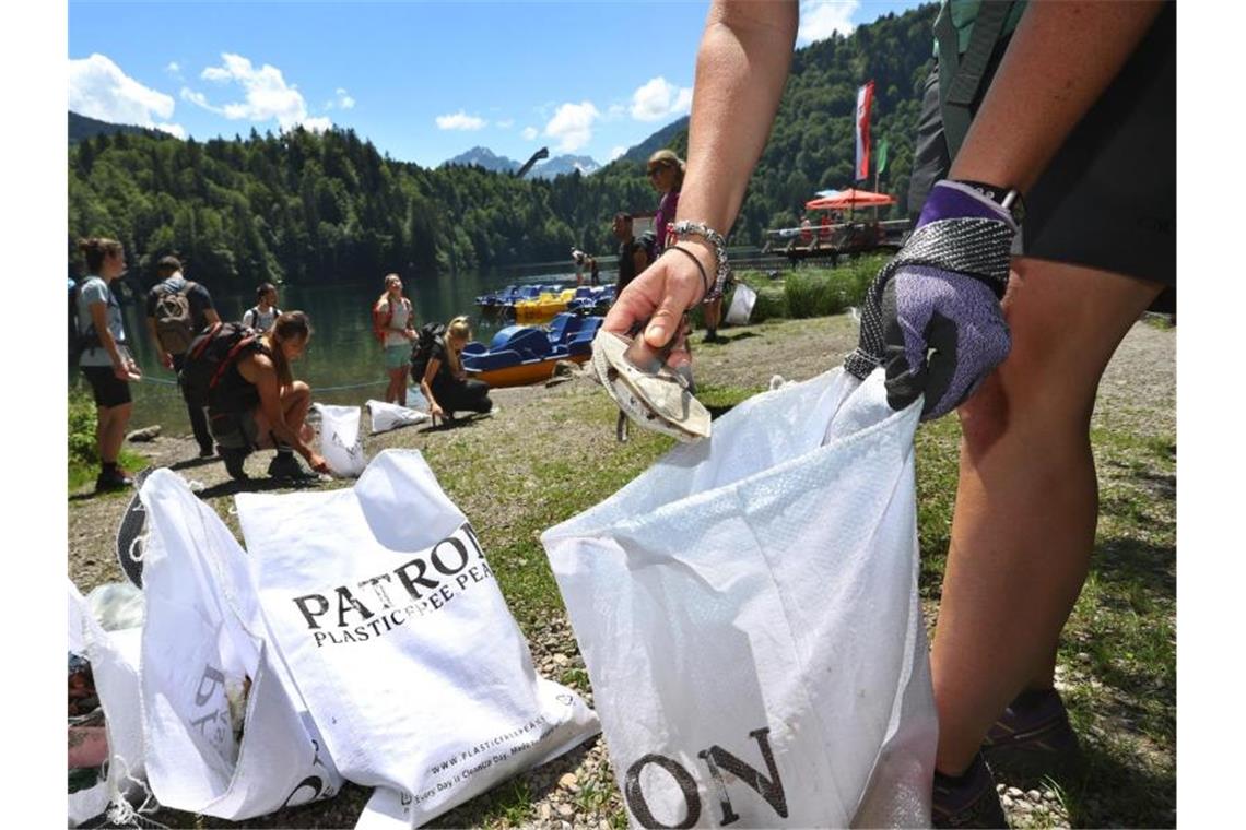 Eine Gruppe von Freiwilligen sammelt Müll am Ufer des Freibergsees. Foto: Karl-Josef Hildenbrand/dpa/Archivbild