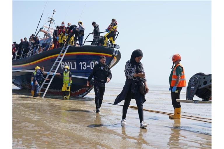 Eine Gruppe von Menschen, bei denen es sich vermutlich um Migranten handelt, geht von Bord des örtlichen Rettungsboots in Kent, nachdem sie nach einem Zwischenfall mit einem kleinen Boot im Ärmelkanal aufgegriffen wurde. Foto: Gareth Fuller/PA Wire/dpa