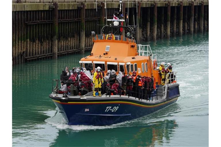 Eine Gruppe von Menschen, bei denen es sich vermutlich um Migranten handelt, wird an Bord des Dover-Rettungsboots an Land gebracht. Foto: Gareth Fuller/PA Wire/dpa