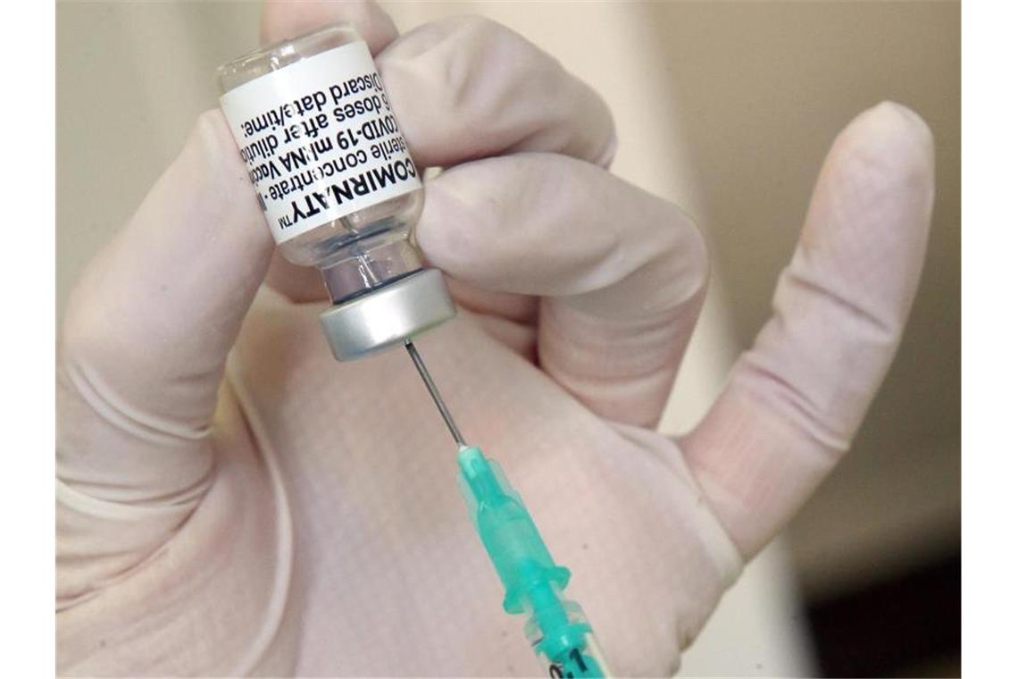 Impf-Auffrischung laut Stiko spätestens 2022 nötig Eine Hausärztin zieht in ihrer Praxis eine Spritze mit dem Impfstoff des Herstellers Biontech/Pfizer auf. (Archivbild). Foto: Wolfgang Kumm/dpa