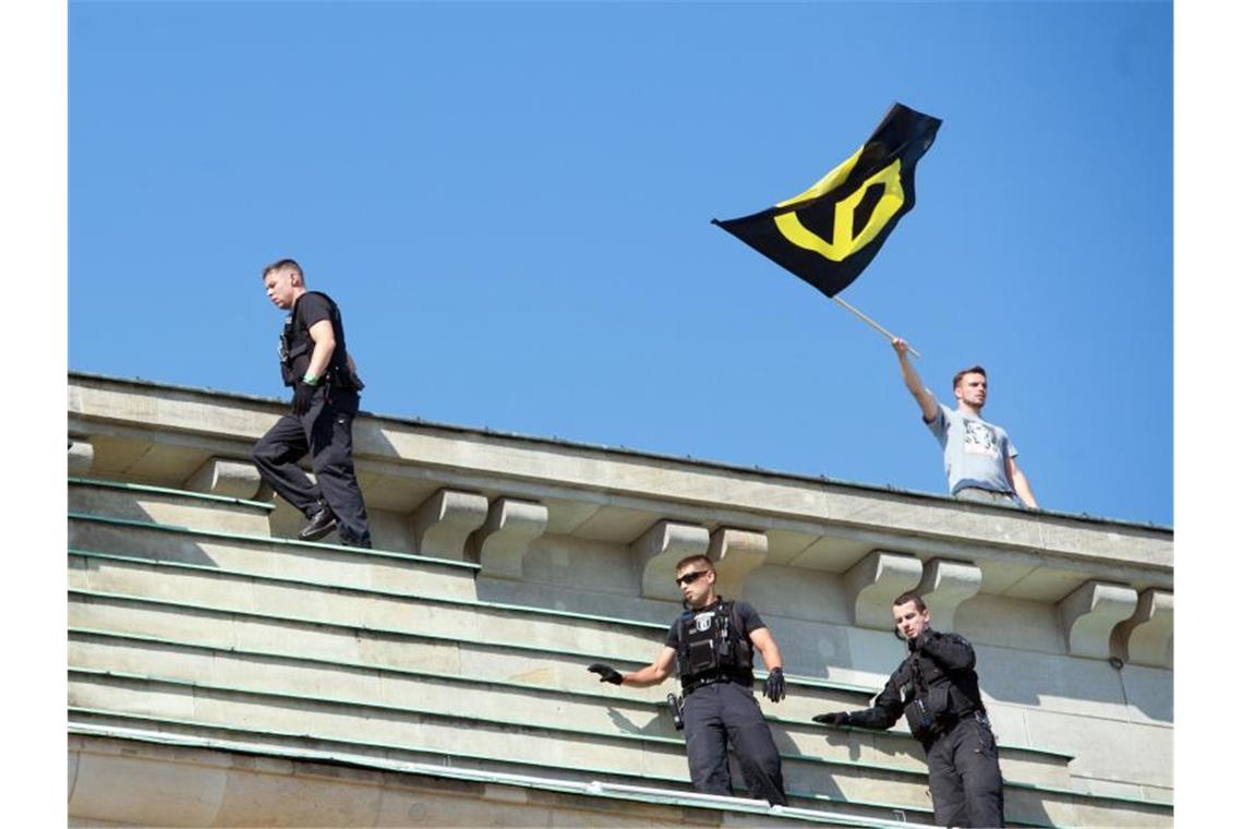 Verfassungsschutz: Identitäre Bewegung ist klar rechtsextrem Eine ihrer spektakulärsten Aktionen im August 2016: Polizisten holen einen Aktivisten der Identitären vom Brandenburger Tor. Foto: Paul Zinken