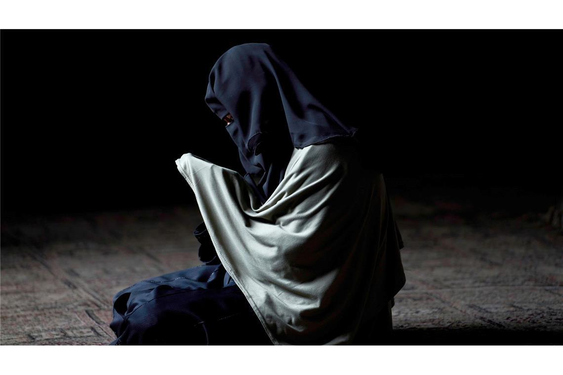 Eine in einen Niqab gehüllte muslimische Frau aus Kaschmir betet am Schrein eines islamischen Heiligen.