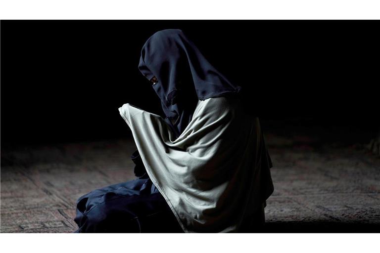 Eine in einen Niqab gehüllte muslimische Frau aus Kaschmir betet am Schrein eines islamischen Heiligen.