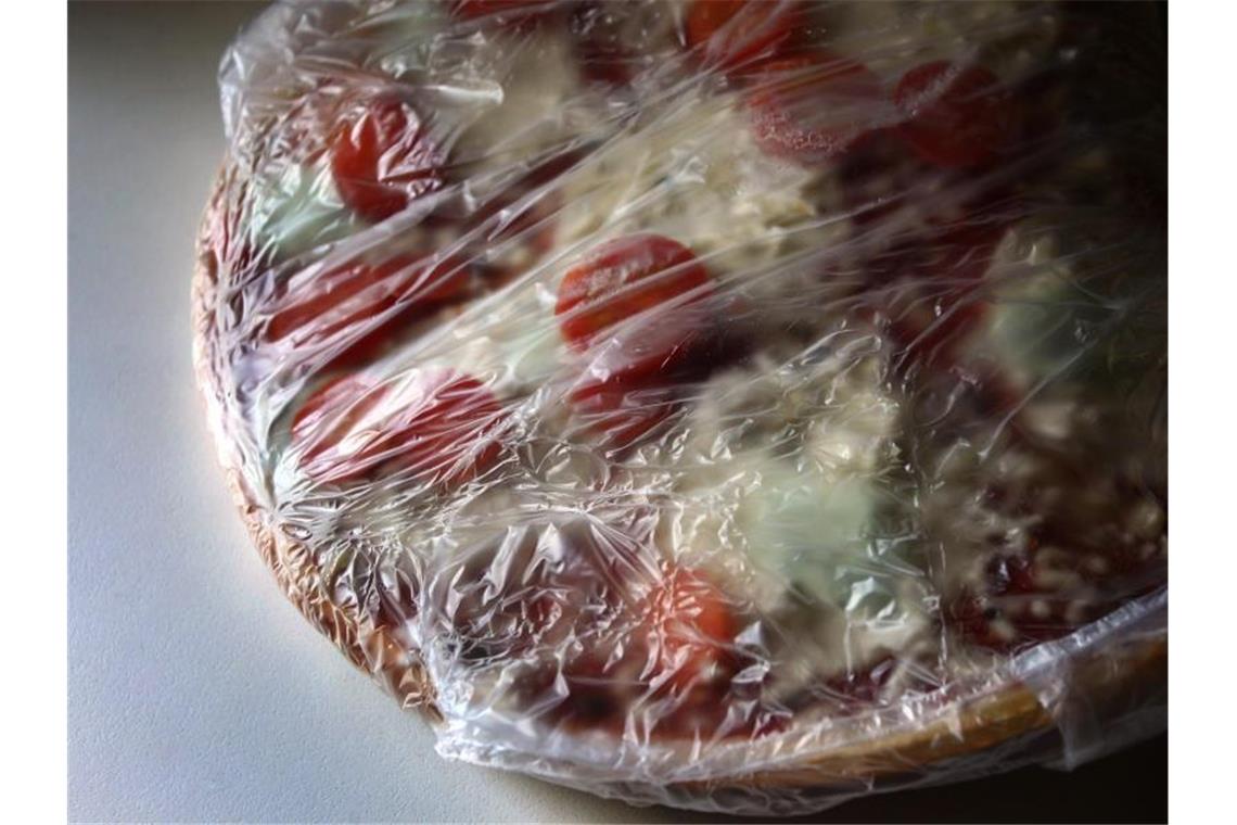 Eine in Plastikfolie gepackte tiefgekühlte Fertigpizza. Foto: picture alliance / Karl-Josef Hildenbrand/dpa/Symbolbild