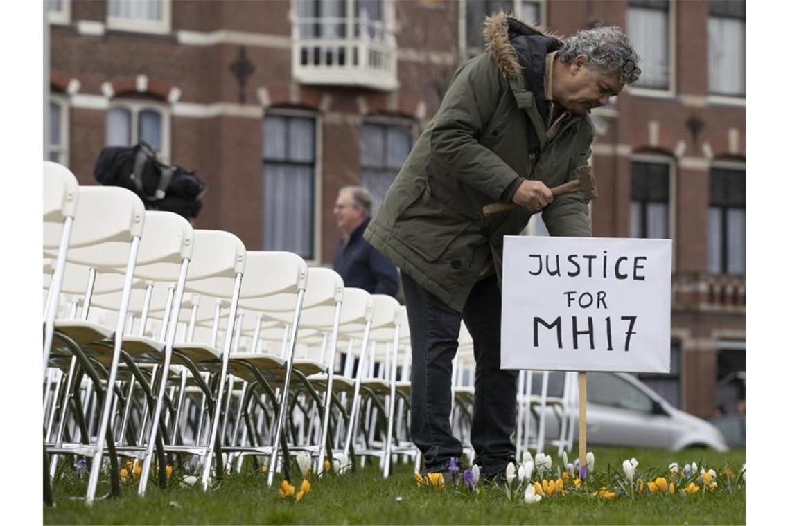 Eine Installation mit 298 symbolischen leeren Stühlen gegenüber der russischen Botschaft in Den Haag erinnert an die Opfer. Foto: Peter Dejong/AP/dpa