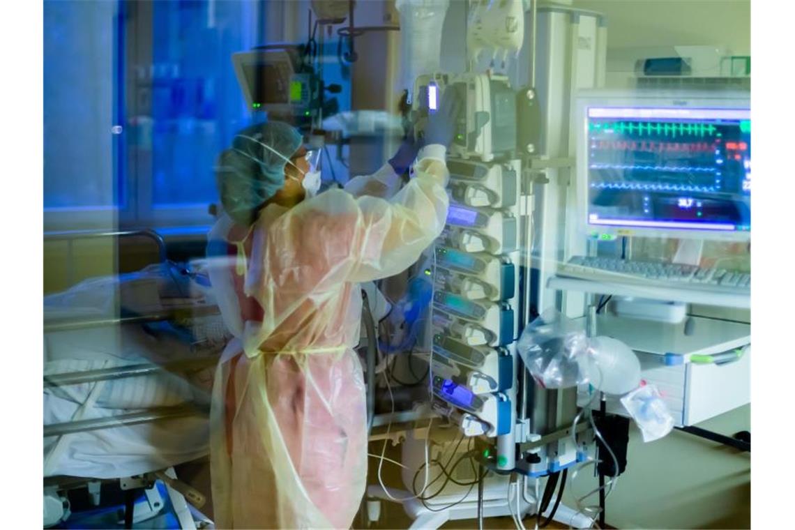 Harmloses Omikron? Wie kritisch die Infektion ist Eine Intensivfachpflegerin betreut auf einer Intensivstation einen Covid-19-Patienten. (Archivbild). Foto: Christoph Soeder/dpa